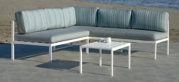 Sofá rinconera para jardín fabricado en aluminio. La estructura es de color blanco y los cojines de exterior en el asiento son de color gris y el respaldo de rayas grises y azules.