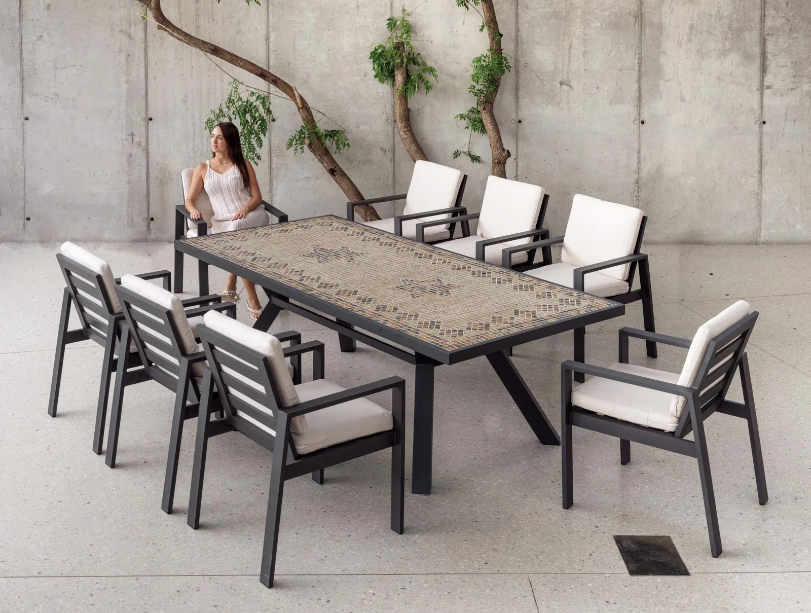 Mesa de mosaico exterior. Fabricada en aluminio o hierro. Se encuentra sobre una terraza interior.